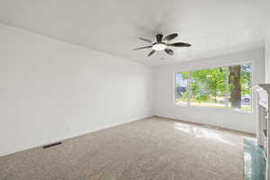 Carpeted empty room featuring visible vents, baseboards, and ceiling fan