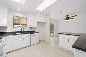 Kitchen with a sink, a skylight, plenty of natural light, and white dishwasher