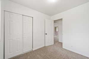 Unfurnished bedroom with carpet flooring, baseboards, and a closet