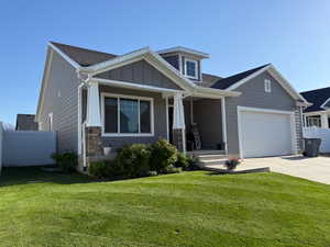Craftsman house featuring concrete driveway, fence, a porch, and a front lawn