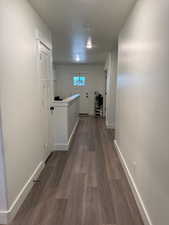 Hallway featuring baseboards and dark wood-style floors