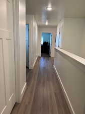 Hallway featuring baseboards and dark wood-style flooring