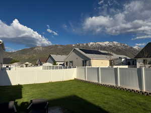 View of yard with a fenced backyard, a mountain view, and a residential view