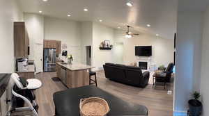 Living area with recessed lighting, light wood-style flooring, ceiling fan, and vaulted ceiling