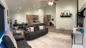 Living area with a ceiling fan, visible vents, wood finished floors, baseboards, and recessed lighting