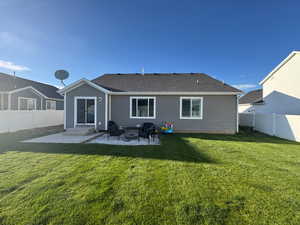 Back of house with a lawn, a fenced backyard, and a patio area