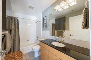 Bathroom featuring toilet, tile patterned flooring, vanity, and visible vents
