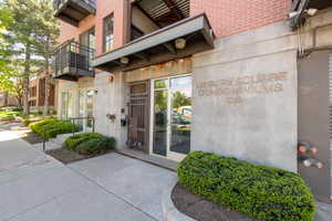 Doorway to property featuring a balcony and brick siding