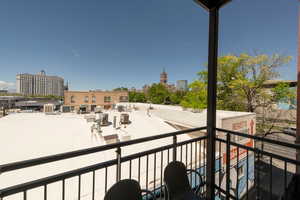 Balcony featuring central AC unit and a city view