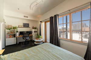 Carpeted bedroom featuring access to exterior, visible vents, and multiple windows