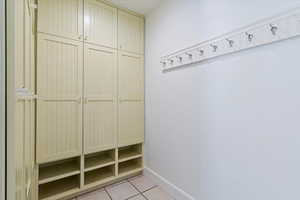 Mudroom with light tile floors and Built in cabinets and storage.