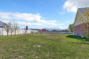 View of yard with a mountain view and fence