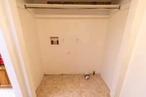 Clothes washing area featuring laundry area, light tile patterned floors, electric dryer hookup, washer hookup, and hookup for a gas dryer