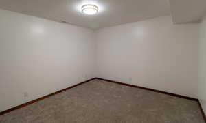 Spare room featuring carpet flooring, baseboards, and visible vents