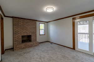 Unfurnished living room featuring ornamental molding, visible vents, and carpet floors