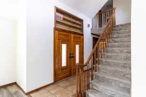 Foyer entrance featuring baseboards and stairs