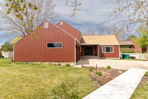 View of front of property with a front yard and driveway