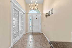 Foyer featuring a chandelier and baseboards