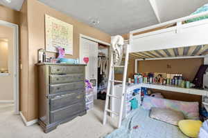 Carpeted bedroom featuring a closet and baseboards