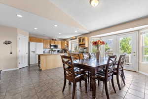 Dining room featuring vaulted ceiling, baseboards, light tile patterned floors, and recessed lighting