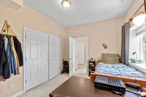 Bedroom featuring light carpet and baseboards