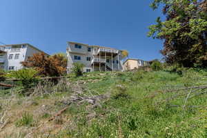 Back of house featuring stairway and a wooden deck