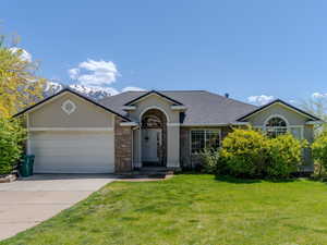 Single story home featuring roof with shingles, driveway, a garage, stucco siding, and a front lawn