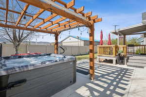 View of patio / terrace featuring a hot tub, a pergola, and a fenced backyard