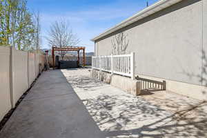 View of patio / terrace with a hot tub, a pergola, and a fenced backyard