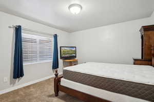 Carpeted bedroom featuring baseboards