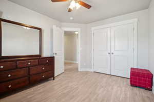 Unfurnished bedroom with baseboards, ceiling fan, light wood finished floors, and a closet