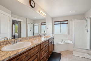 Bathroom with double vanity, a bath, a shower stall, and a sink