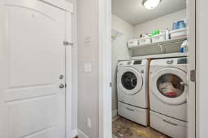 Clothes washing area featuring independent washer and dryer and baseboards