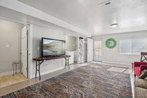 Living area with baseboards, tile patterned floors, washer and dryer, and visible vents