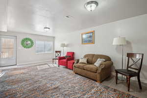 Living room with baseboards, visible vents, and tile patterned floors