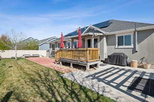 Rear view of property with a patio, stucco siding, a lawn, a fenced backyard, and roof with shingles