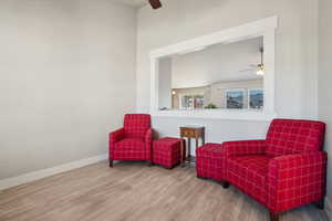 Sitting room featuring baseboards, a ceiling fan, and wood finished floors