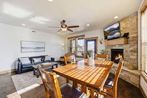 Dining space featuring hardwood / wood-style flooring, a fireplace, ceiling fan, and recessed lighting