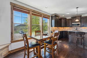 Dining area featuring dark wood-style flooring and recessed lighting