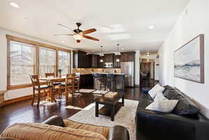 Living room featuring dark wood-style flooring and ceiling fan