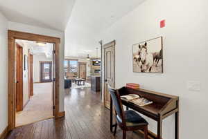 Corridor featuring baseboards and dark wood-type flooring