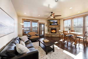 Living room with a fireplace, a ceiling fan, hardwood / wood-style floors, and recessed lighting