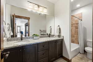 Full bath featuring double vanity and shower / bath combo with shower curtain