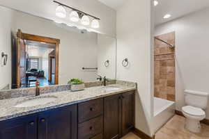 Bathroom featuring a sink, toilet, double vanity, and visible vents