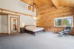 Bedroom with wood ceiling, log walls, beam ceiling, and carpet floors
