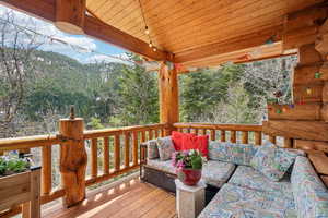 Deck featuring a view of trees, a mountain view, and outdoor lounge area