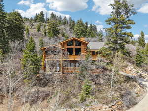 Exterior space featuring a chimney, a deck, and log siding