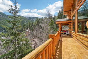 Wooden deck featuring a wooded view and a mountain view