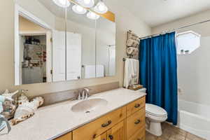 Full bathroom featuring shower / tub combo with curtain, vanity, and toilet