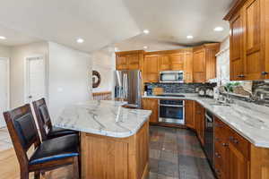 Kitchen with recessed lighting, stainless steel appliances, decorative backsplash, and a sink